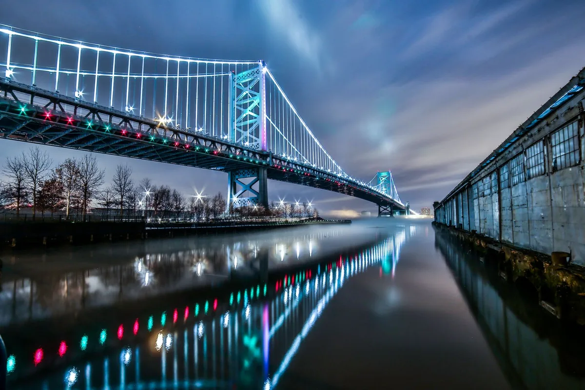 The Benjamin Franklin Bridge illuminated at night over the Delaware River